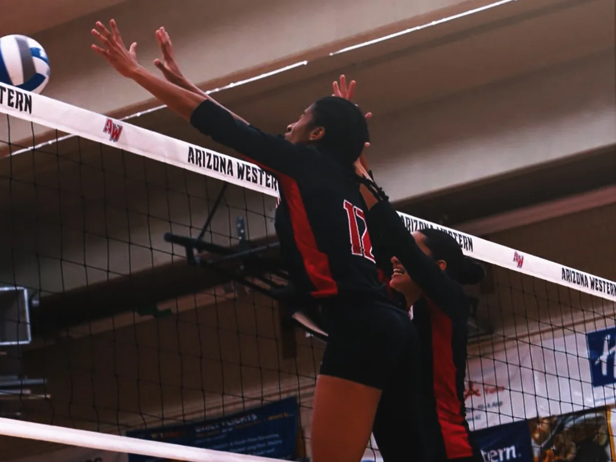 Atleta de voleibol bloqueando en la red en un partido universitario